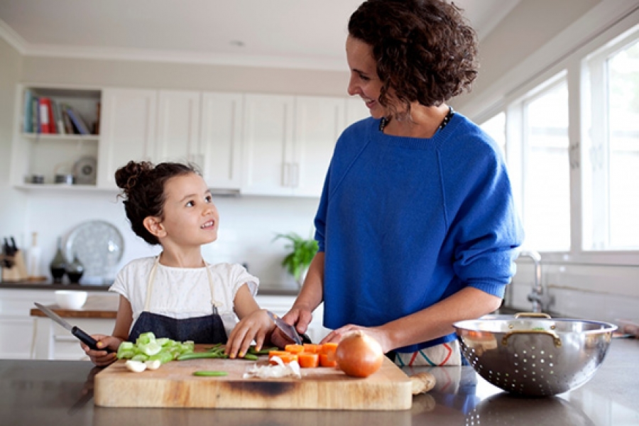 Mother and daughter chopping vegetables together